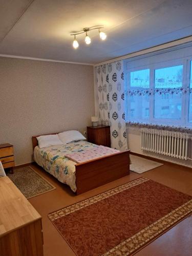 een slaapkamer met een bed en een groot raam bij Linte apartment 