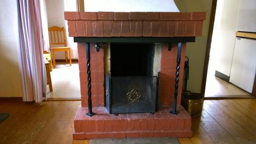 a brick fireplace in the middle of a room at Långasjönäs Camping & Stugby in Karlshamn