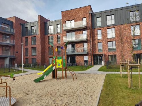 a playground in front of a brick building at TOTU TODAY-STARA CEGIELNIA APARTAMENTY, Faktura VAT, self check-in in Poznań