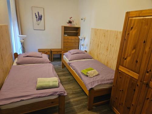 a room with two beds and a dresser at Németh Apartmanok in Zalakaros