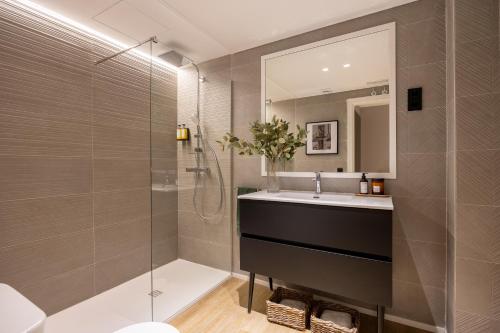 a bathroom with a shower and a sink and a mirror at Edmond Vibes Puerta del Sol Suites in Madrid
