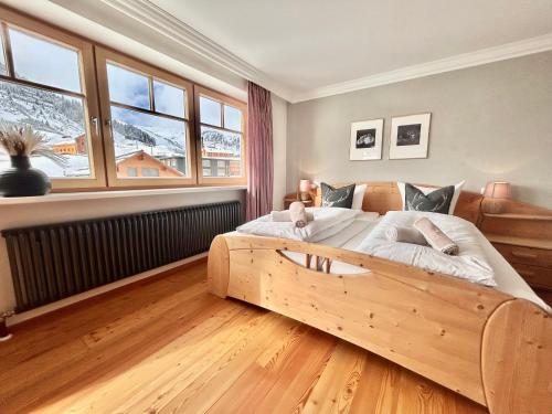 a bedroom with a large bed with a wooden frame at Haus Wallis by stayFritz - Ski-In Ski-Out Zimmer 'garni' am Arlberg in Warth am Arlberg