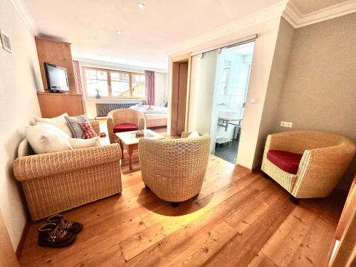 a living room with wicker chairs and a couch at Haus Wallis by stayFritz - Ski-In Ski-Out Zimmer 'garni' am Arlberg in Warth am Arlberg