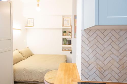 une petite chambre avec un lit et une table dans l'établissement Charmant studio_ Champs-Élysées, à Paris