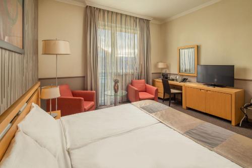 a hotel room with a bed and a television at Mamaison Hotel Andrassy Budapest in Budapest
