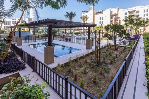 a swimming pool with a gazebo and trees at Luxury 1BD apartment in Madinat Jumeirah Living in Dubai