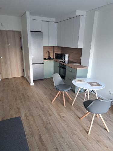 a kitchen with two chairs and a table at 2 kambarių butas ramioje vietoje in Palanga