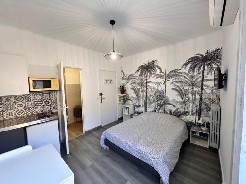- une chambre avec un lit recouvert de palmiers dans l'établissement Studios climatisés proche mer, à Nice
