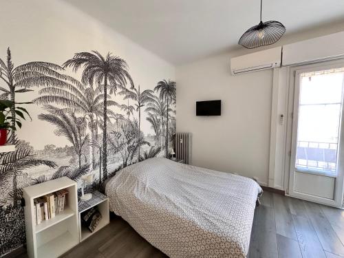 - une chambre avec un lit orné d'une fresque murale sur les palmiers dans l'établissement Studios climatisés proche mer, à Nice