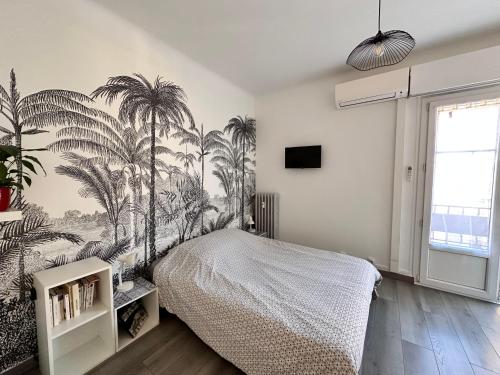 ニースにあるStudios climatisés proche merのベッドルーム1室(ヤシの木の壁画が施されたベッド1台付)