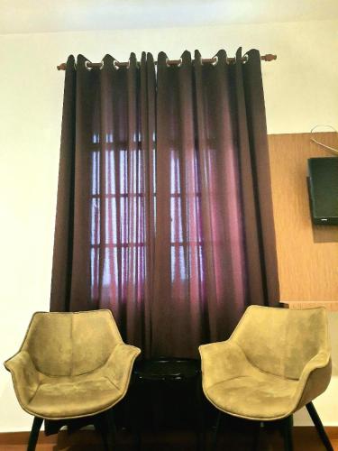 two chairs sitting in front of a curtain at Dz Residence Tunjong in Kota Bharu