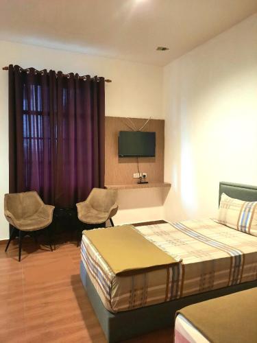 a hotel room with two beds and a tv at Dz Residence Tunjong in Kota Bharu