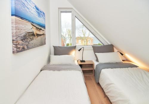 três camas num quarto com uma janela em Paradise Suite - Penthouse mit Meerblick em Timmendorfer Strand