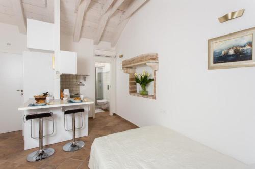 Cette chambre blanche dispose d'un lit et d'une cuisine. dans l'établissement Apartments Bottega, à Dubrovnik