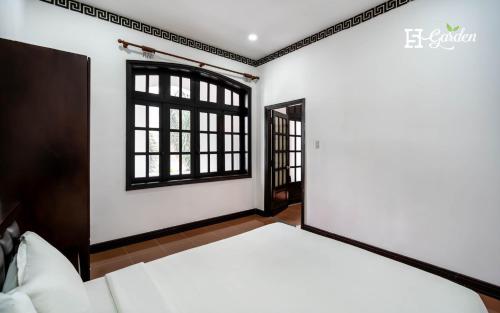a bedroom with a bed and a window at 5H Garden in Ho Chi Minh City