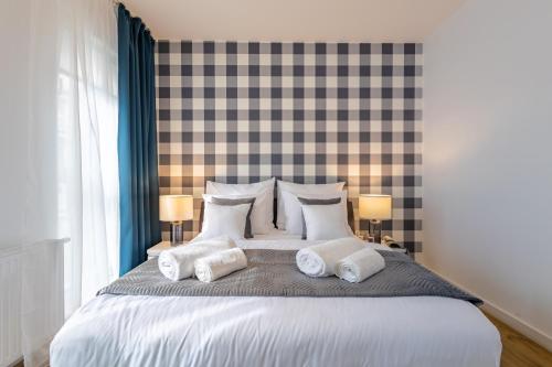 a bedroom with a large bed with three pillows at Deluxe Apartments by The Railway Station Wroclaw in Wrocław