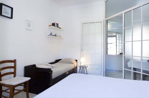 1 dormitorio con cama, silla y espejo en Bilocale Imperatrice, en San Remo