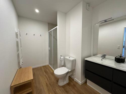 a white bathroom with a toilet and a sink at Le Raphaël - Sur les hauteurs de Bordeaux in Bordeaux