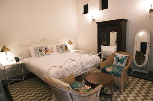 1 dormitorio con 1 cama, 2 sillas y espejo en Vivaana Museum Hotel, en Nawalgarh