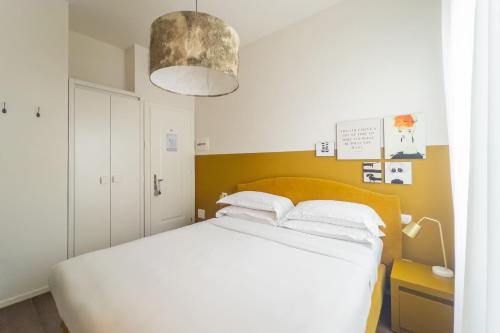 a bedroom with a white bed and a pendant light at Lu. b&b in Cervia