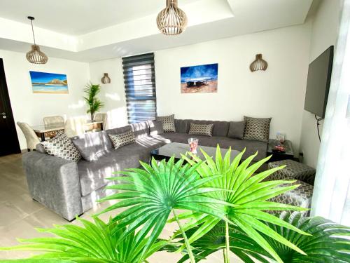 a living room with a couch and a table at Luxurious Golf & Sea View Beach Apartment with Pool Access - Cocon de Taghazout Bay in Taghazout