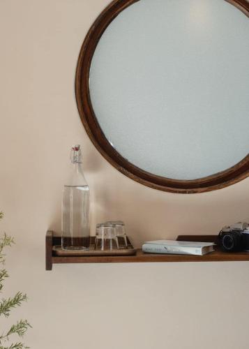 a bottle on a shelf under a mirror at Dreamers: home & coffee in Xuan An