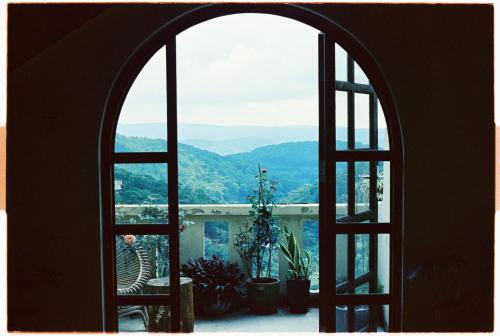 an open window looking out at a mountain view at Dreamers: home & coffee in Xuan An
