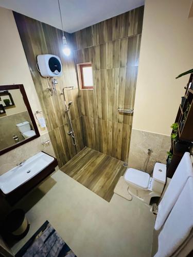 a bathroom with a shower with two toilets and a sink at Ella Family House in Ella