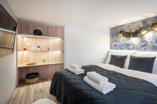 a bedroom with a large bed with towels on it at Petite Elegance Apartment in Budapest