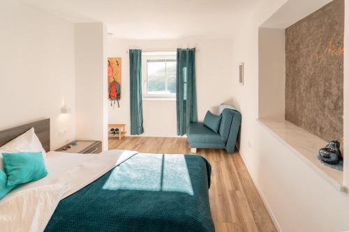 a bedroom with a bed and a blue chair at Apartment Niederhaushof in Parcines