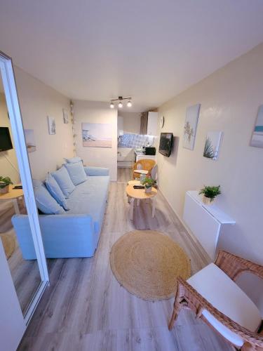 sala de estar con sofá azul y mesa en Studio 1 piece vacances proche de la mer, en Le Grau-du-Roi