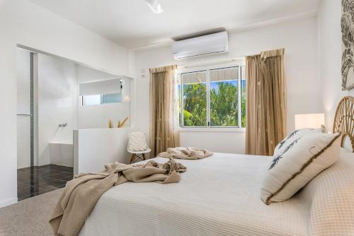 a white bedroom with a large bed and a window at Pet Friendly Oasis By The River, Noosaville in Noosaville