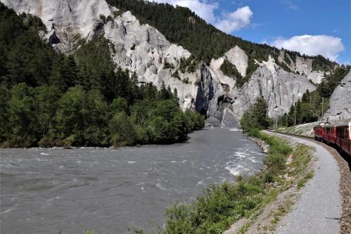 a train traveling along a river next to a mountain at 10min zu den Bergbahnen Tiefgarage & Wifi inkl. Bergsicht & Ruhe in Trinsermühle