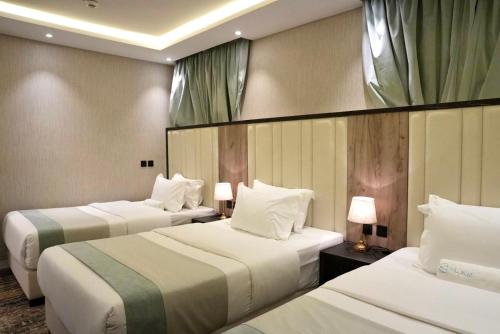 a hotel room with two beds and two lamps at لـحظــات حــراء in Jeddah