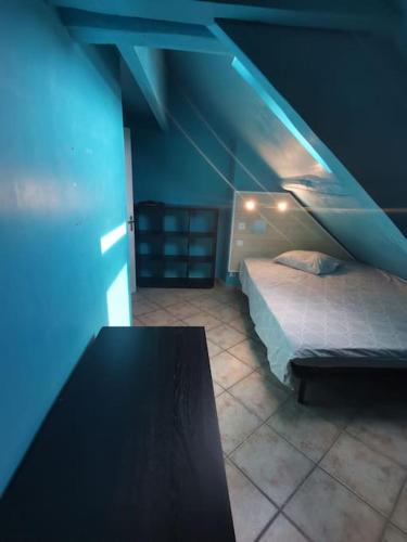 1 dormitorio con 1 cama y 1 mesa en una habitación en Appartement cozy avec mezzanine, en Souppes-sur-Loing