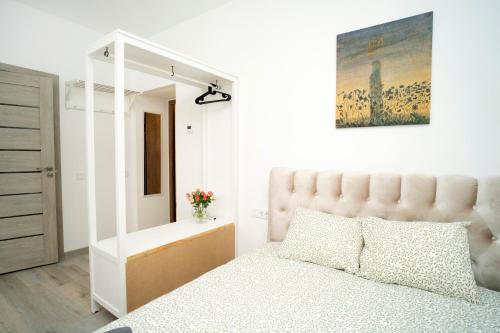 ein weißes Schlafzimmer mit einem Bett und einem Spiegel in der Unterkunft Central Station Apartment No6 in Kaunas