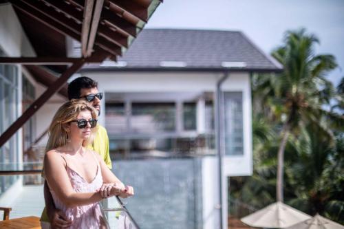 a man and a woman standing in front of a house at Beacon By The Bay Villas and Suites by the Clarks in Matara