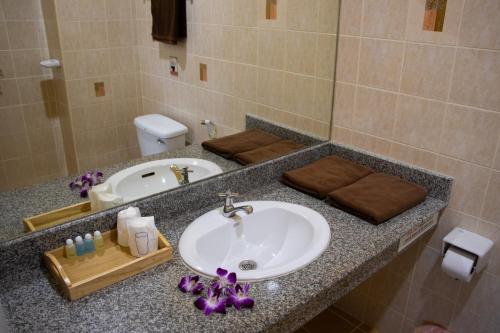 a bathroom counter with a sink and a toilet at Thai Life Guesthouse Khaolak in Khao Lak