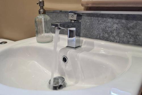 a sink with a faucet with water coming out of it at Potter's Retreat by Spires Accommodation an adorably quirky place to stay in Newcastle upon Tyne in Longport