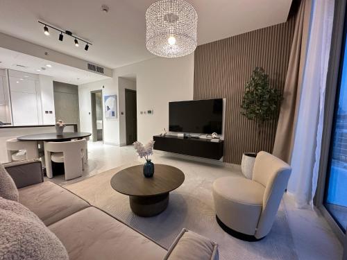 een woonkamer met een bank en een tafel bij Oraya - Skyline Serenity at 1BR in District One in Dubai