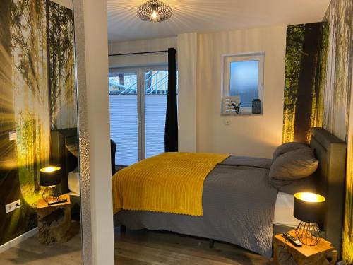 ein Schlafzimmer mit einem Bett mit einer gelben Decke in der Unterkunft Wood II Appartement in Bad Salzuflen
