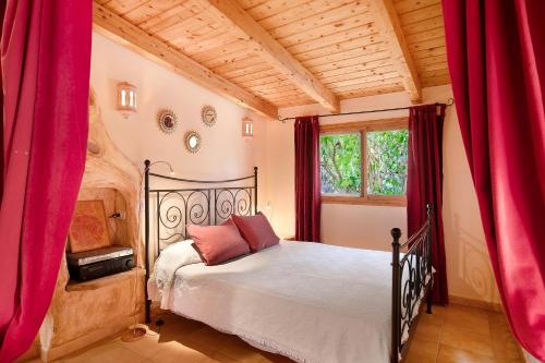 a bedroom with a bed with red curtains at Casa Anakena in Guía de Isora