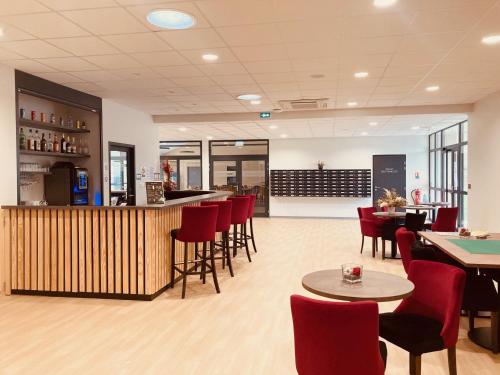 a restaurant with a bar and tables and chairs at Résidence Services Séniors in Montignac