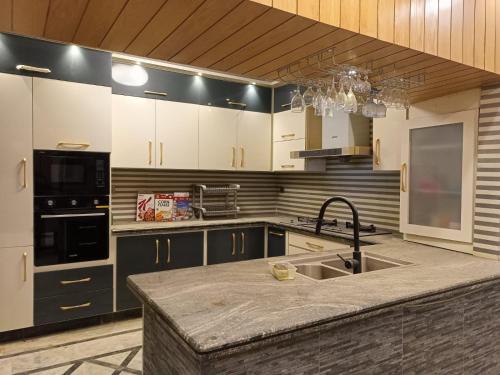 a kitchen with white cabinets and a sink at White Lotus Karachi in Karachi