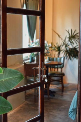 a glass door with a table and chairs in a room at Dreamers: home & coffee in Xuan An