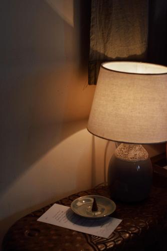 a lamp sitting on a table next to a paper at Dreamers: home & coffee in Xuan An