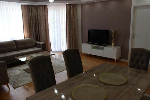 uma sala de estar com uma mesa e uma televisão em Apartment Ilidza-SK 2 em Sarajevo