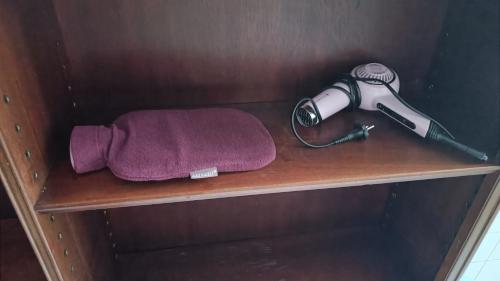 a shelf with a hair dryer and a purple towel at La Vie En Rose: Elegance and Art in Berlin