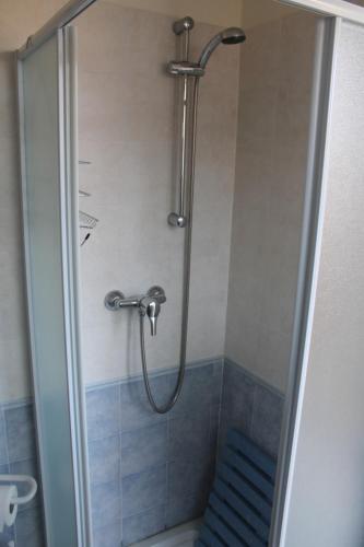 une douche dans une salle de bain avec une porte vitrée dans l'établissement Appartamento 6 posti letto a 5 minuti dalla spiaggia, à Lumio