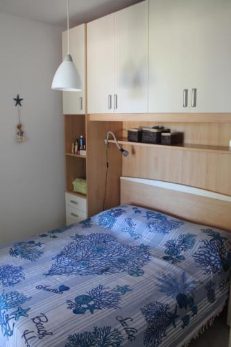 une chambre avec un lit avec une couette bleue et blanche dans l'établissement Appartamento 6 posti letto a 5 minuti dalla spiaggia, à Lumio